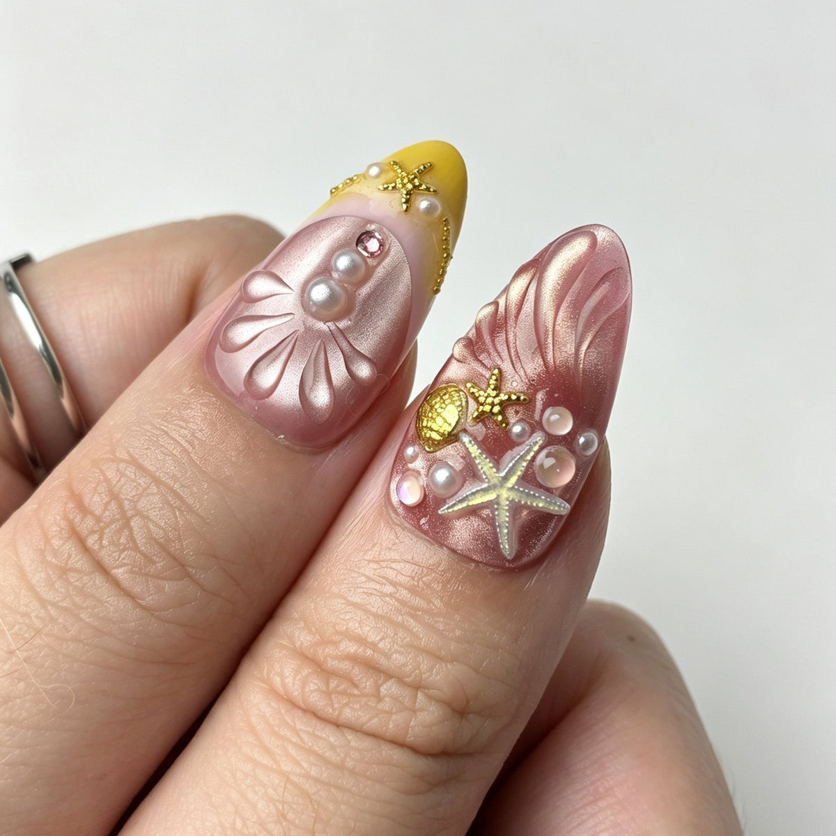 Close‑up of 3D seashell starfish pearl detail on pink yellow mermaid press on nails