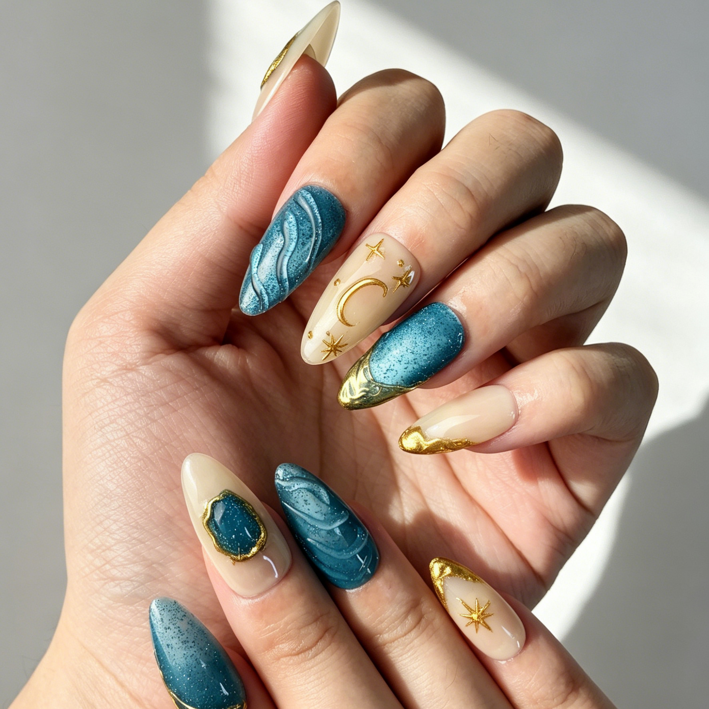 Close Up 3D Textured Nail Art, Celestial Star Moon Gold Metal Ocean Gem Decor, Medium Almond Nude Blue Glitter Press On Nail Detail Shot
