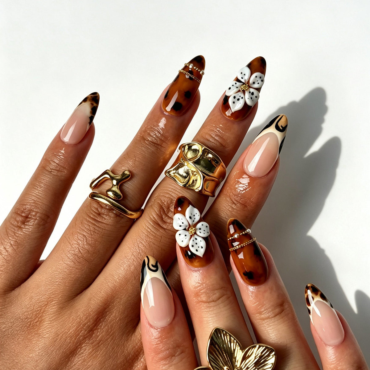 Retro western almond false nails, sheer nude base, tortoiseshell amber ombre, tiger French tips and 3D flowers