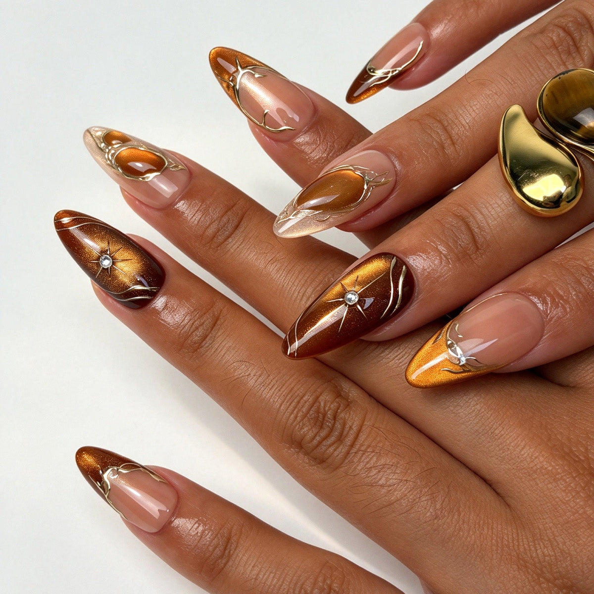 Amber Star handmade almond press on nails, warm amber cat eye gold star rhinestone nail art on hand