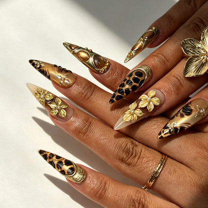 Model hand wearing Aureate Feline vintage gold leopard stiletto press‑on false nails