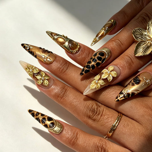 Model hand wearing Aureate Feline vintage gold leopard stiletto press‑on false nails
