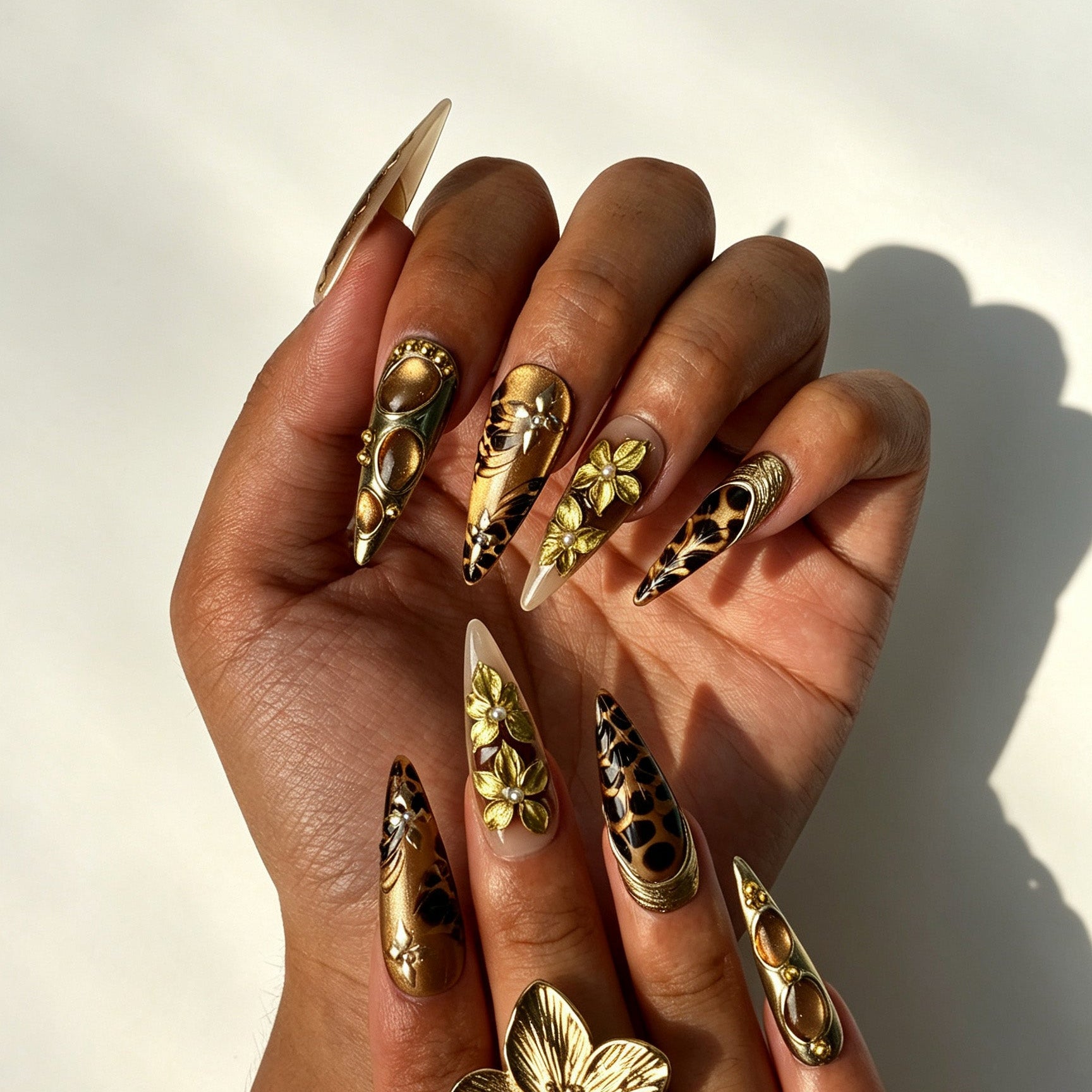 Luxury vintage‑wild stiletto press‑on nails with pearl and metallic embossed details on hand
