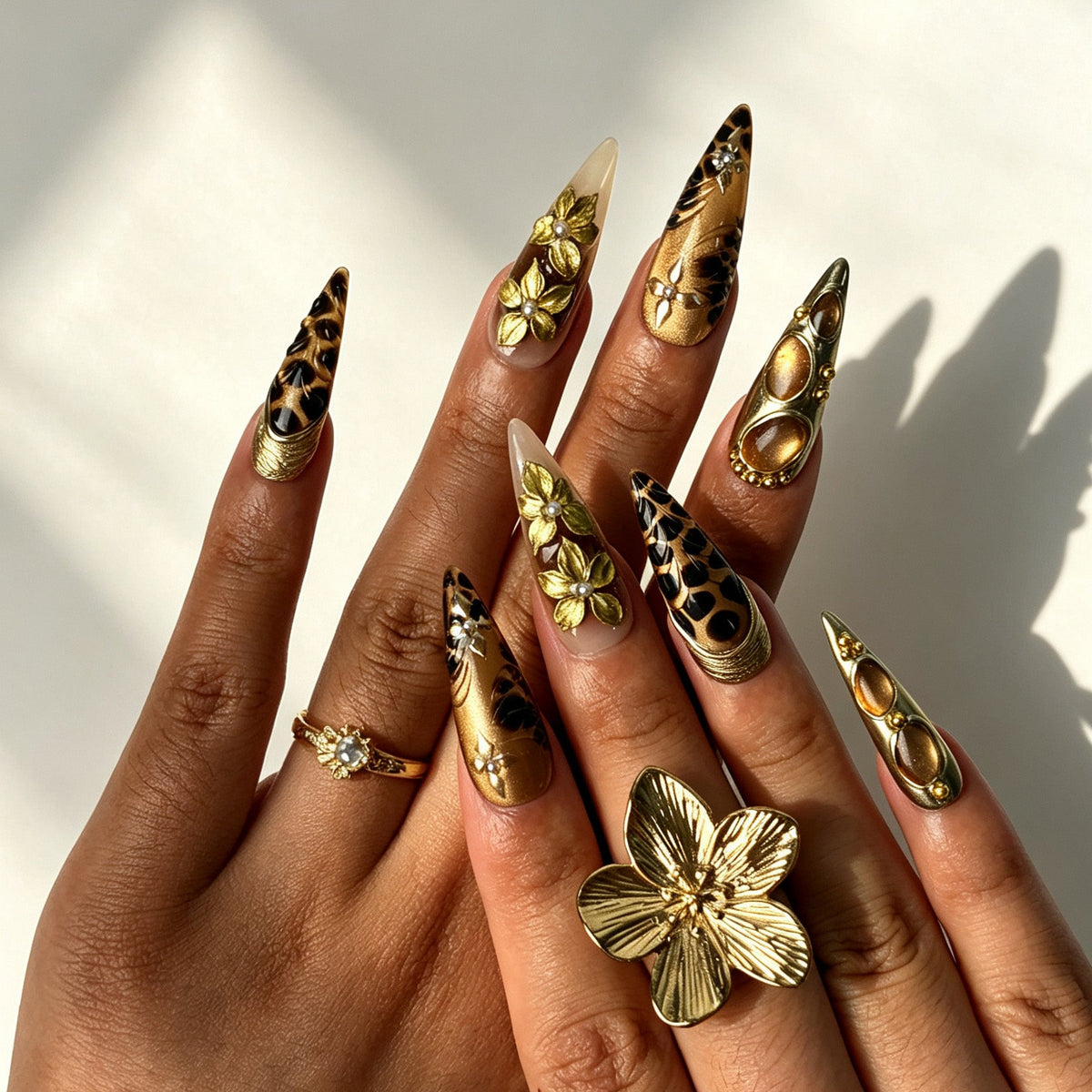 Close‑up of hand with 3D carved gold flower leopard print long stiletto press‑on nails