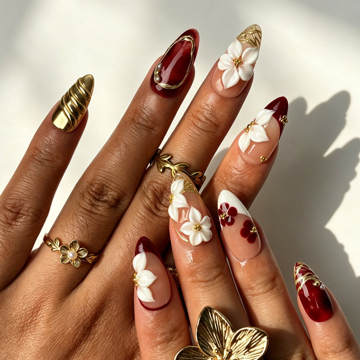 Romantic almond false nails, sheer nude burgundy ombre with 3D white flower and gold wire details