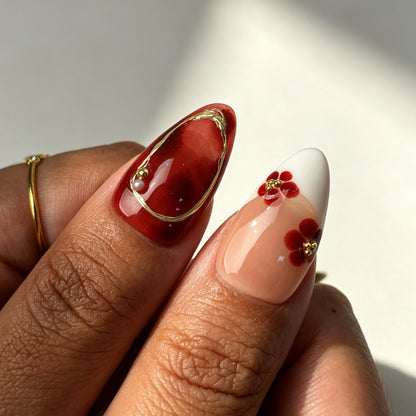 Elegant almond press on nails, sheer nude base, burgundy ombre, 3D white flower, gold wire and pearl bead