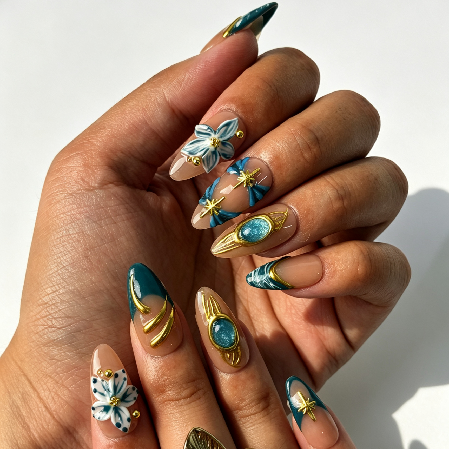 Jade Filigree aqua cat eye almond press on nails worn on hand, gold filigree gem, star charms and blue floral elegant nail art