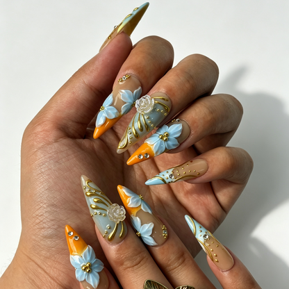 Citrus Aqua nude gradient stiletto false nails close-up, pale blue floral, gold line and clear rhinestone vacation manicure