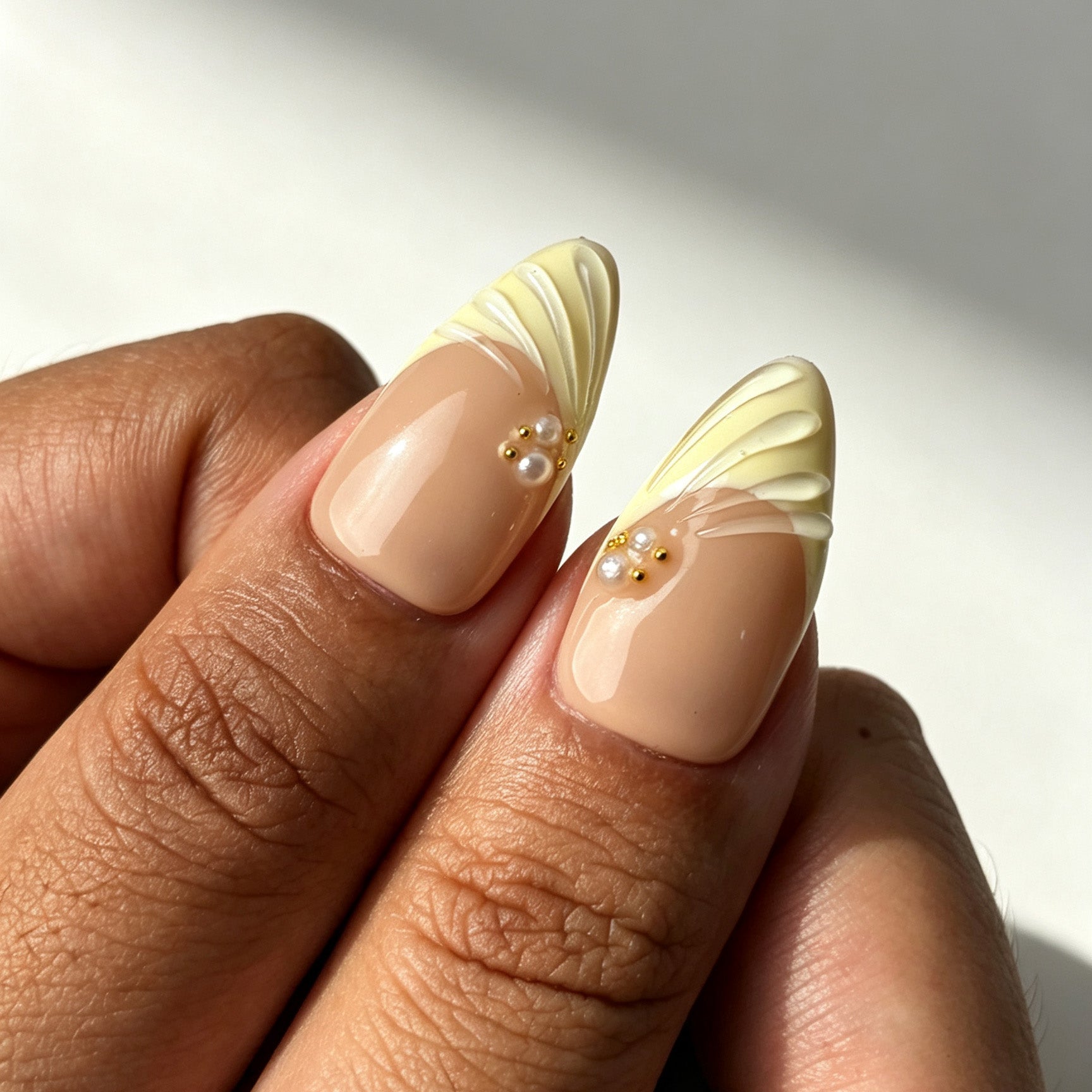 Soft ivory gold almond nails real‑hand lifestyle manicure