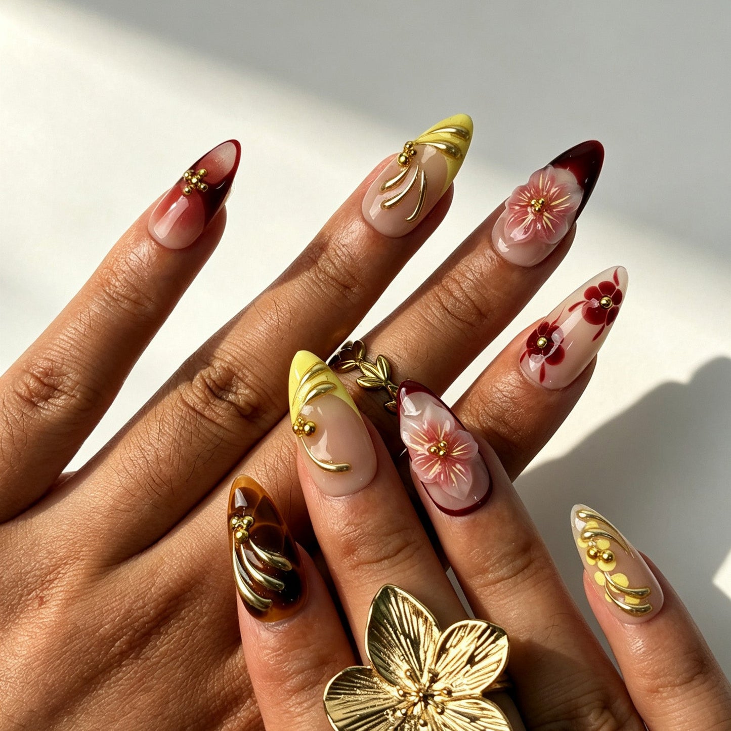 Handmade wine red ombre press‑on nails with 3D pink sakura and gold metal swirl details