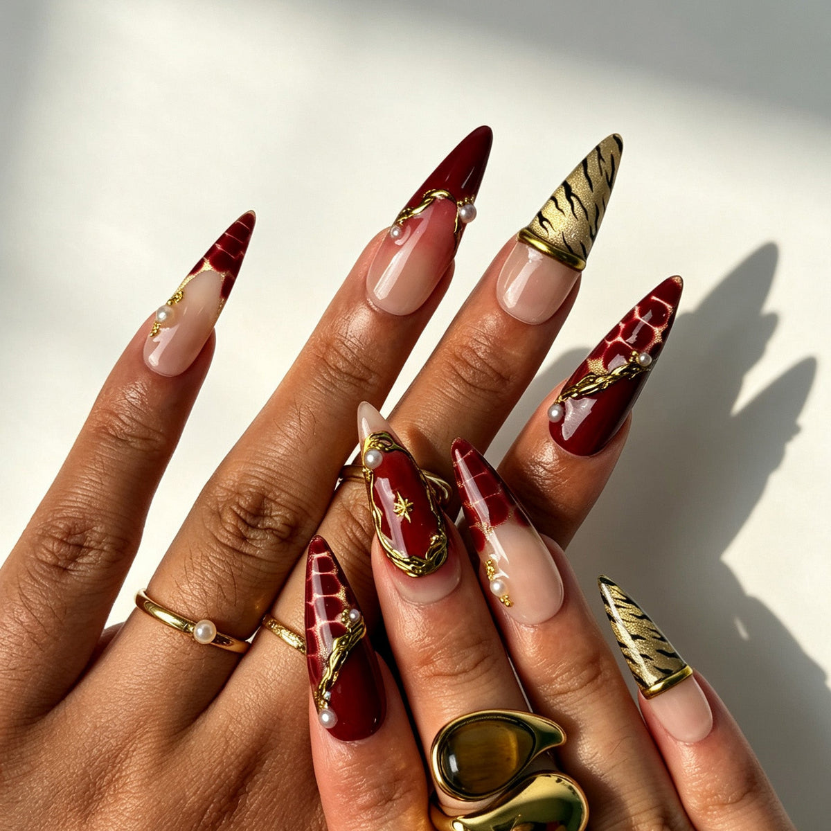 Romantic boho stiletto false nails, nude red ombre, gold metal trim, pearl ornament and metallic gold tiger print