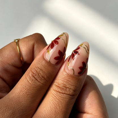 Elegant almond press on nails, sheer nude base, wine red-black ombre, maple leaf, gold wire and gold bead details