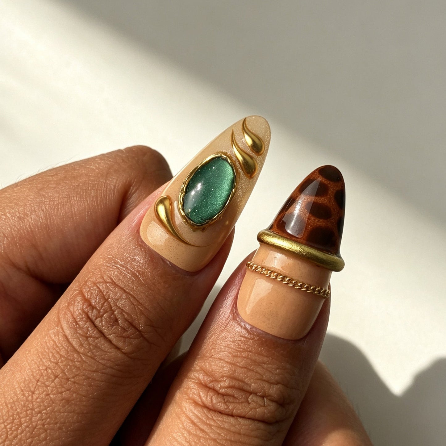 Hand wearing Emerald Regal luxury almond press on nails with emerald gem decor