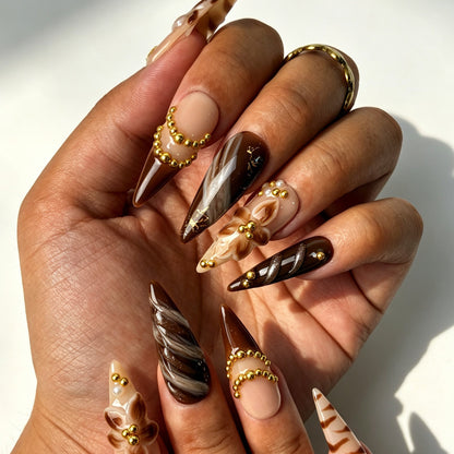 Mocha Bloom autumn press‑on nails on hands, nude coffee brown marble with 3D flower and gold bead chain details
