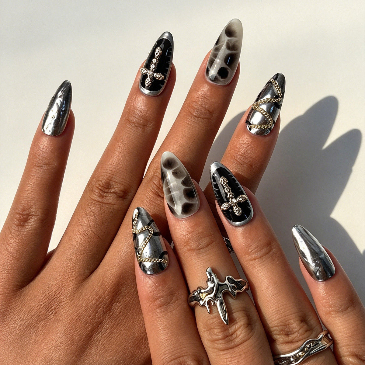 Closeup of hand with black silver star cross fake nails