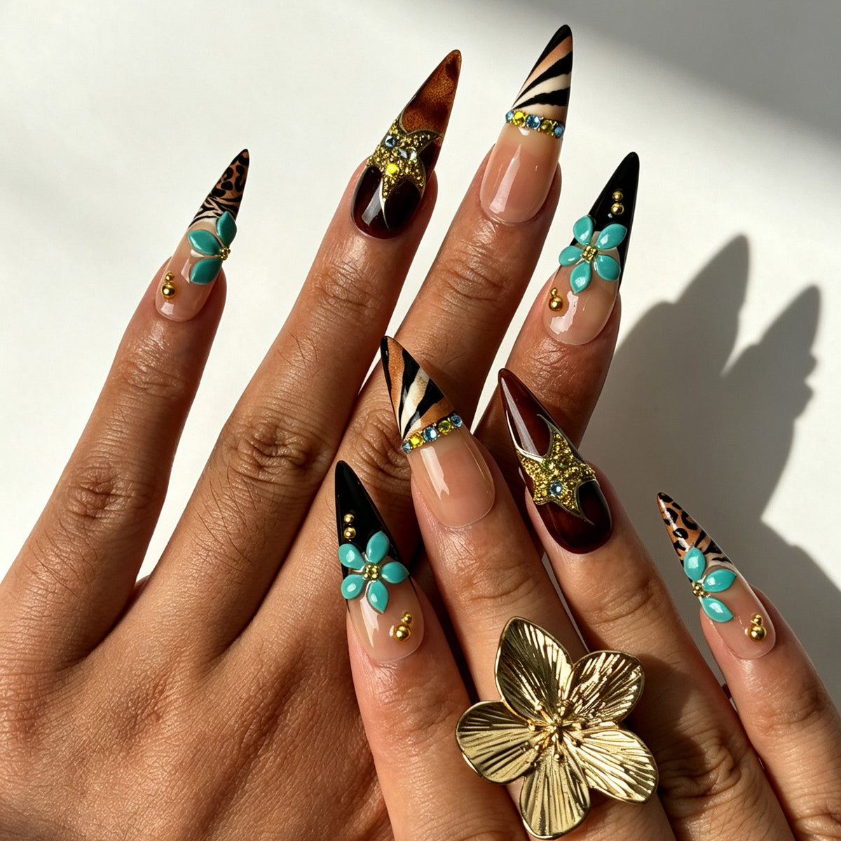 Model hand wearing Panther Noir retro stiletto press‑on nails with teal 3D flower decor