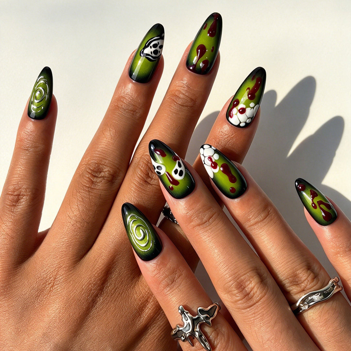 Closeup of hand with neon green ghost skeleton reusable false nails