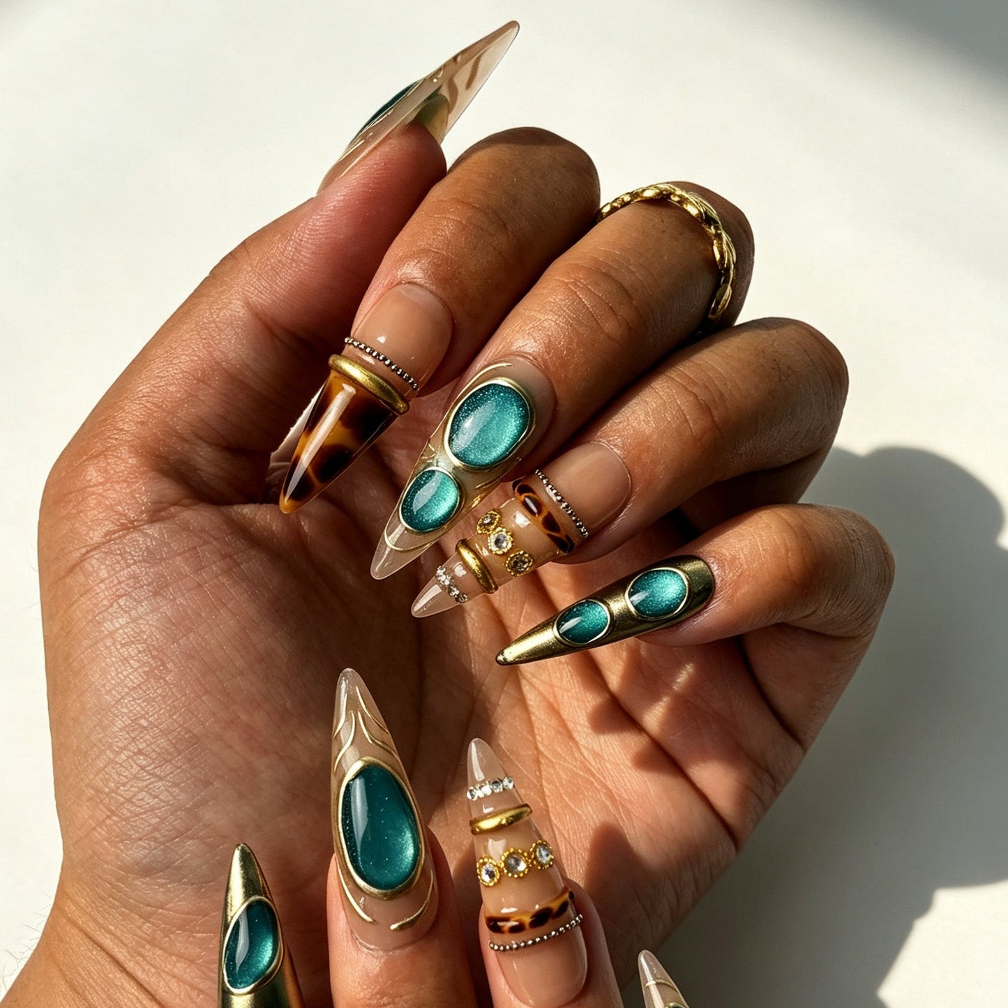 Close‑up of hand wearing vintage turquoise relic stiletto false nails