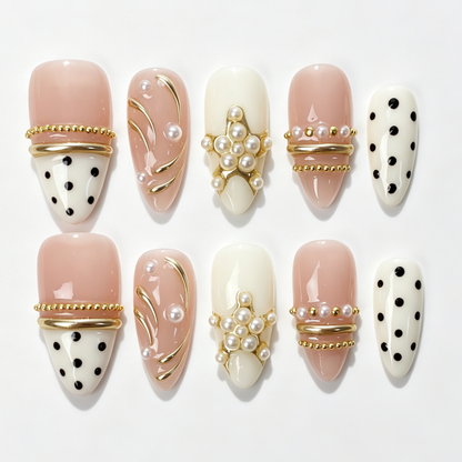 Blush Dot medium almond press on nails, blush nude cream dual tone base, black polka dot, clustered pearl beads and curved gold line decor