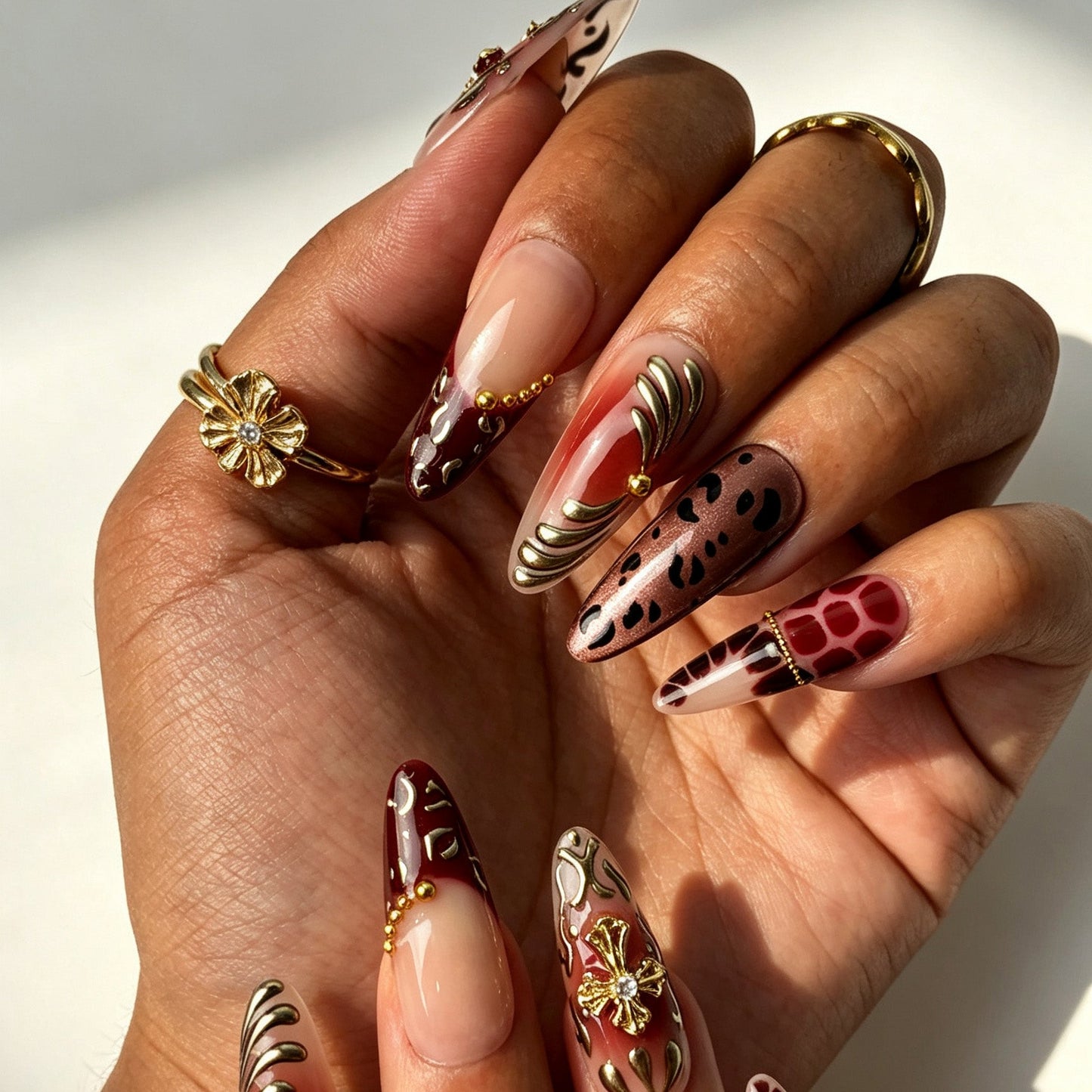 Wine Felis bold vintage press‑on nails close‑up, wine red tortoiseshell 3D gold cross decorations