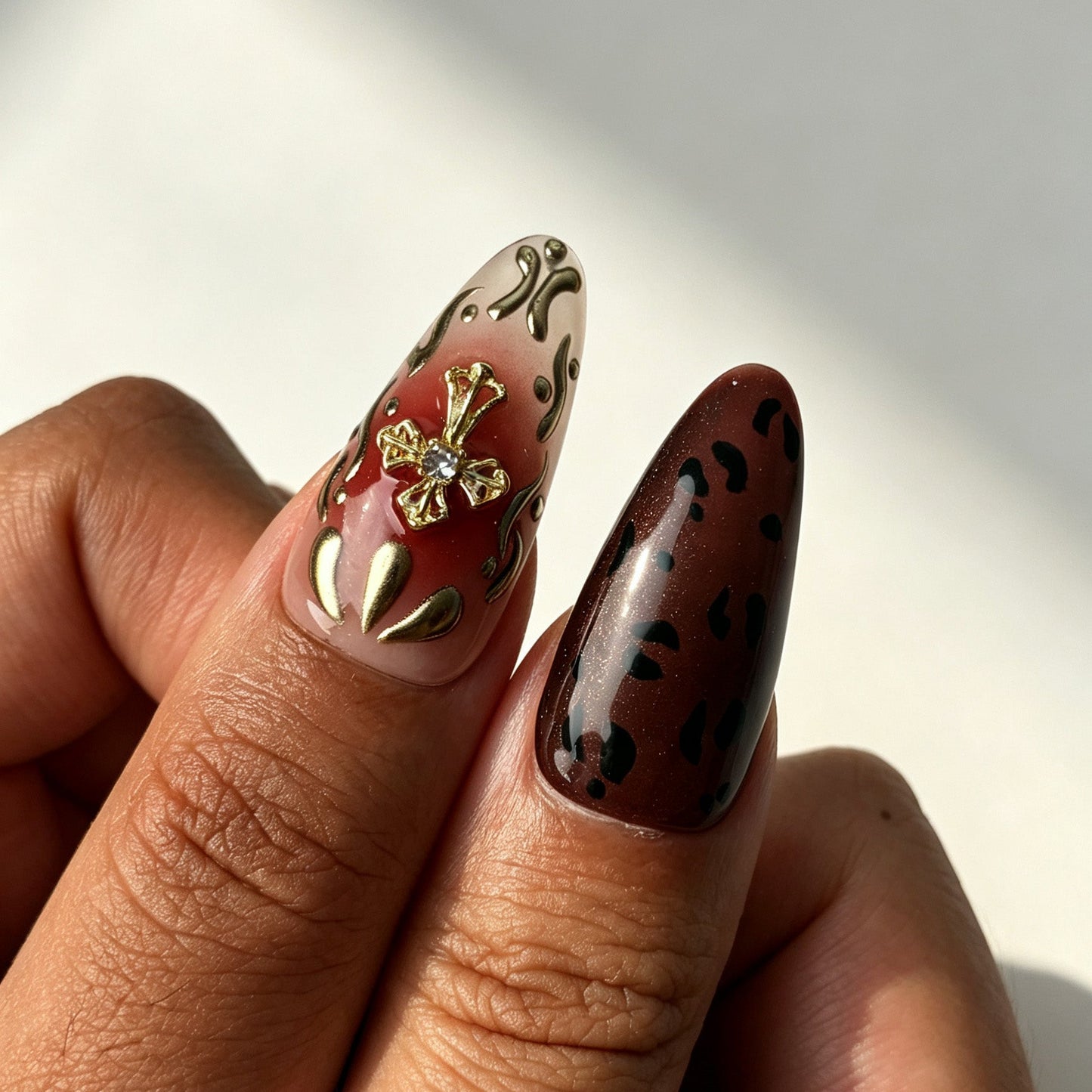 Close‑up view of Wine Felis almond false nails, wine‑red gradient leopard tortoiseshell gold bead details
